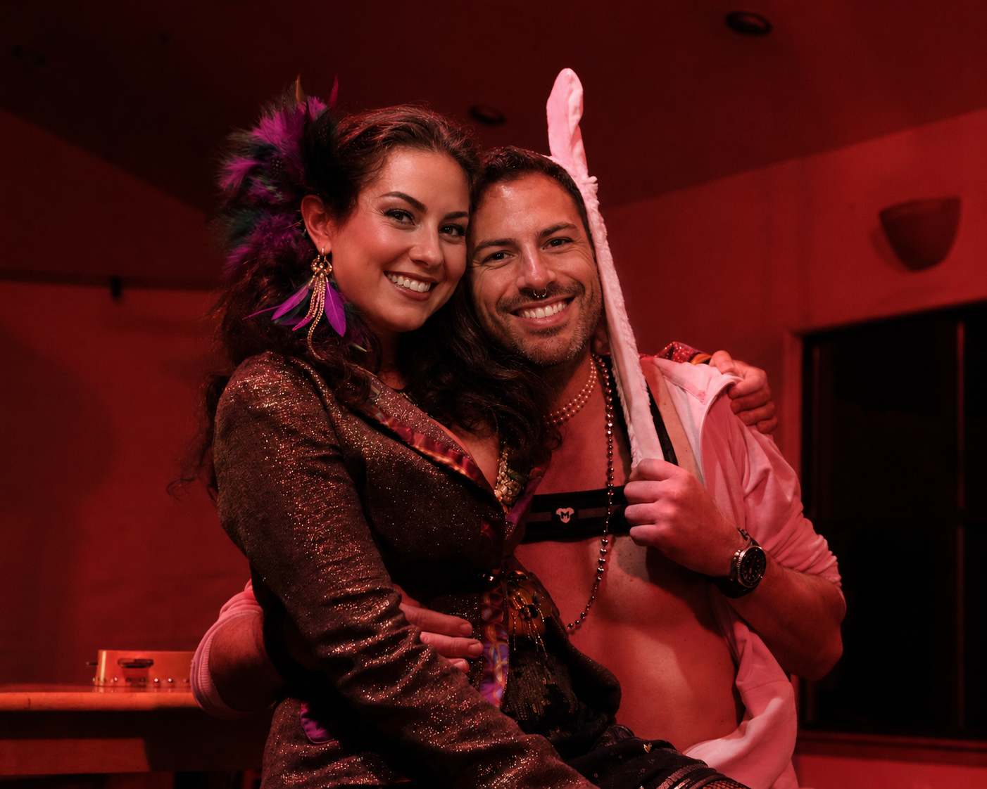 Two costumed guests smiling together at a private evening event